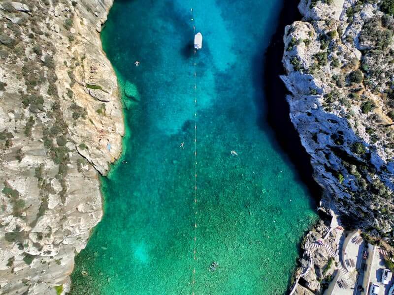 Aerial photograph of a green body of water surrounded by rocks.